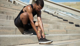 Muscular Dark-skinned Male Athlete In Black Sportswear Holding H