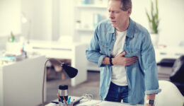 Man Standing at His Desk Holding His Chest Is Heart Disease Curable