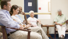 Five People Sitting in a Doctor’s Office Waiting Room Waiting to See the Doctor Why Do Doctors Take So Long